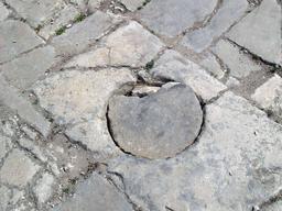 Plaque d'égout romaine en place sur une voie. Source : http://data.abuledu.org/URI/540854ca-plaque-d-egout-romaine-en-place-sur-une-voie